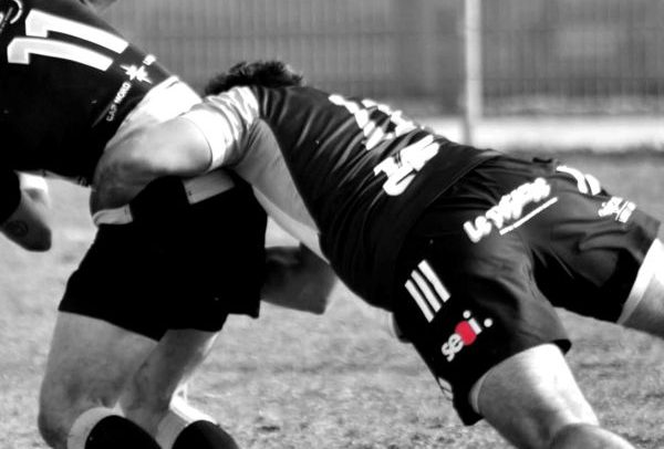 Plaquage d'un joueur de l'Olympique Bisontin, logo SEOI sur la tenue